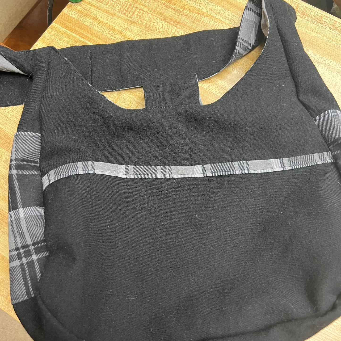 Black and white plaid edging the black pockets and side pockets of the purse. 